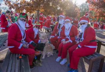 Group of people dressed as Santa with a dog