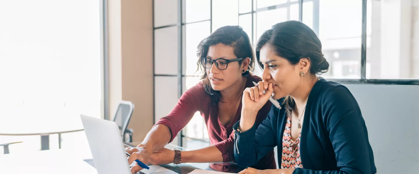 woman helping woman on the computer